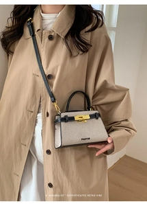 Detail of canvas and leather trapezoid bag with gold twist lock and stitched strap