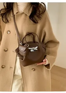 Detail of dark brown lychee leather bucket bag with silver toggle and coin purse