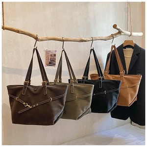 Detail view of large retro tote bags in four colors hanging on a wooden display stand