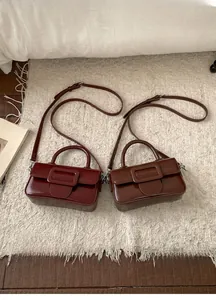 Macro shot of retro matte leather square handbags in burgundy and brown with buckles