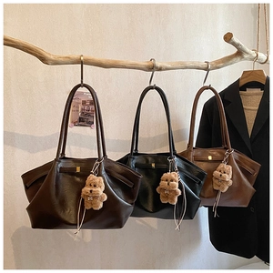 Detailed close-up of three large tote bags in black and brown with cute bear charms