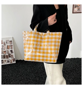 Detail of yellow and white checkered PVC tote bag with stylish waterproof glossy finish