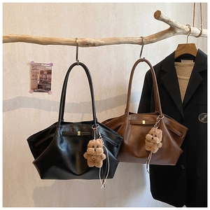 Dettaglio di borse tote vintage con texture in pelle plissettata e ciondoli a orsetto