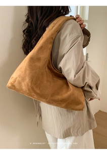 Détail d'un sac cabas en daim marron montrant la texture et le design rétro minimaliste