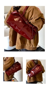 Detail view of large burgundy oil wax leather tote bag with glossy finish and long handles