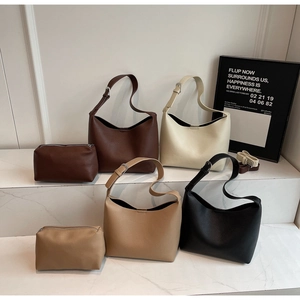 Detail of four-color pebbled leather bucket bags and matching pouches on marble steps