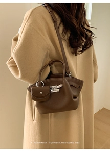 Detail of dark brown litchi leather underarm bag with silver lock and mini pouch pendant
