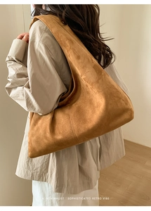 Détail du sac fourre-tout en daim camel montrant sa grande capacité et son style rétro chic