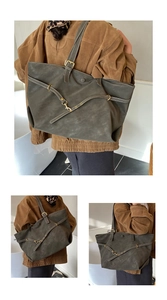 Detail of olive green tote bag showing matte texture and golden metal buckle accents