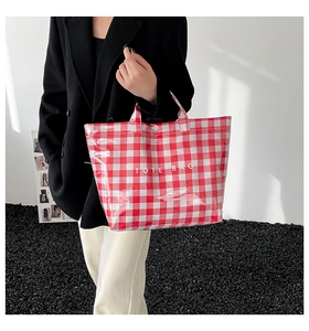 Macro shot of large red checkered canvas tote bag with white TOTE BAG lettering detail
