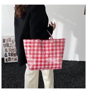 Detail of red and white checkered tote bag with shiny waterproof coating and text