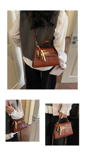 Close-up of brown lychee grain leather handbag with metal turn-lock and tassel detail