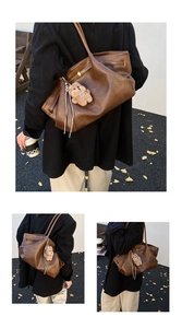 Detail of vintage brown leather tote bag with gold metal hardware and bear pendant
