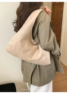 Grand sac fourre-tout en daim beige porté avec un trench olive pour un style chic quotidien