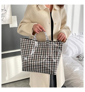 Detail of the waterproof PVC lattice tote bag with bold TOTE BAG lettering and handles