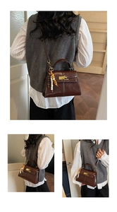 Detail of dark brown vintage leather crossbody bag with metal twist lock and bead charm