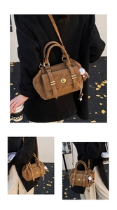 Macro shot of brown suede crossbody bag with gold twist-lock and ginkgo leaf background