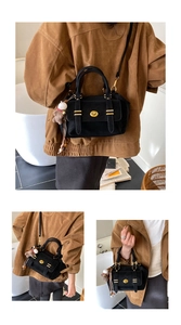 Detail of vintage black suede handbag with gold turn-lock and cute bear charm