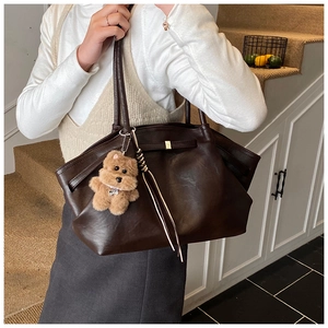 Dettaglio della grande borsa tote vintage marrone con nappa e ciondolo a forma di cane