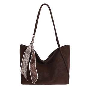 Deep brown leather tote bag with stylish patterned silk scarf on a white background