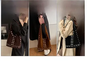 Dettaglio di borse hobo in pelle scamosciata retrò con borchie metalliche in caffè e nero