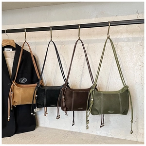 Detail view of four minimalist faux leather shoulder bags in earth tones with bead drawstrings