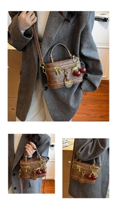 Detail view of retro brown quilted crossbody bag with golden zipper and cherry charm