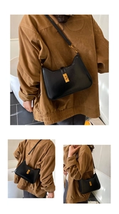 Detail of minimalist black leather half-moon shoulder bag with gold metal clasp