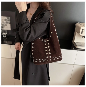 Dettaglio della borsa tote in pelle scamosciata marrone con borchie metalliche argentate