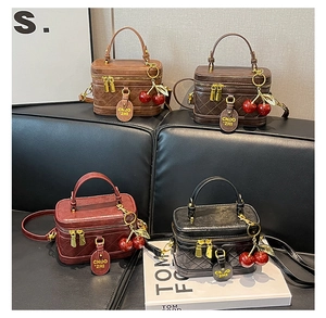 Close-up of quilted leather handbags in four colors featuring golden zippers and cherry charms