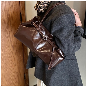 Detail of dark brown glossy oil wax leather shoulder bag with chic silver buckle