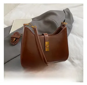 Close-up of the vintage brown shoulder bag showing the gold twist lock and smooth texture