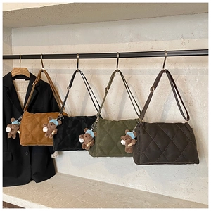 Close-up of diamond-quilted shoulder bags in four colors with cute teddy bear charms