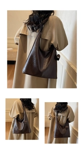 Detail of dark brown leather tote bag with ring charm worn by model in trench coat