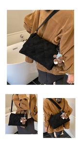 Macro detail of black quilted texture on oversized shoulder bag with plush bear charm