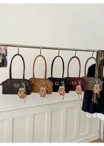 Detail view of five retro leather shoulder bags with gold buckles and plush bear charms