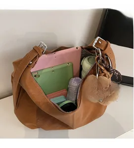Spacious interior of brown tote bag holding two tablets, umbrella, and water bottle