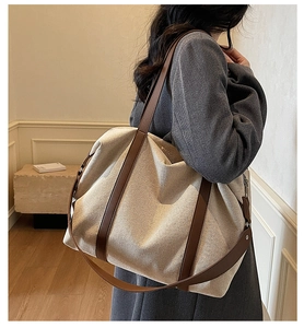 Große beige Canvas-Einkaufstasche mit braunen Lederriemen im lässigen Stil an der Schulter