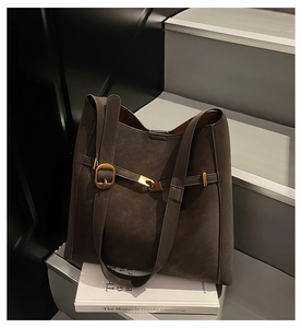 Detailed view of the dark brown matte leather tote with vintage gold hardware and strap