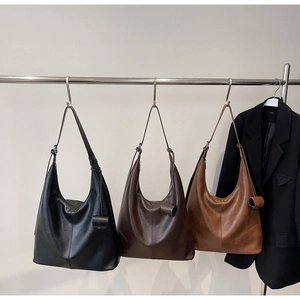 Detail view of large faux leather hobo tote bags in black, chocolate and caramel colors