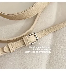 Close-up of beige leather strap with litchi texture and silver metal adjustment buckle