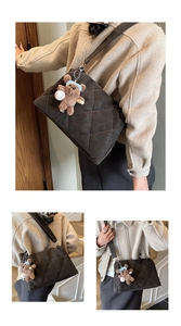 Detailed close-up of dark brown quilted crossbody bag with a cute teddy bear charm