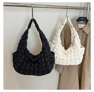 Sacs bandoulière matelassés à texture bulle en noir et blanc dans un décor de style