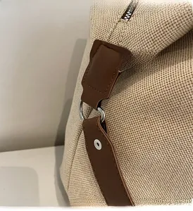 Detail der beigen Segeltuchtasche mit braunem Lederbesatz und silbernem D-Ring-Beschlag