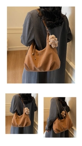 Detail view of large brown suede tote bag with drawstring and cute plush bear charm