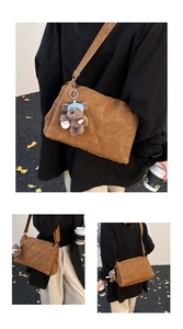 Detailed view of brown quilted crossbody bag with cute plush bear pendant and wide strap