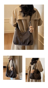 Close-up of charcoal oversized shoulder bag with textured finish and plush bear charm