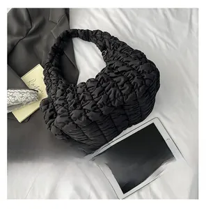 Détail du sac bandoulière noir plissé style puffer avec boucle en métal et texture douce