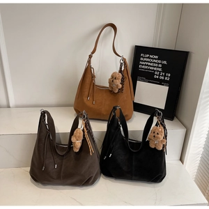 Three textured hobo bags in caramel, dark brown, and black with plush bear charms
