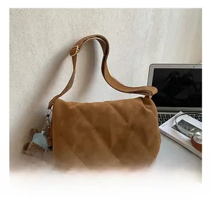 Detailed quilted texture on brown suede tote bag with a cute bear plush keychain